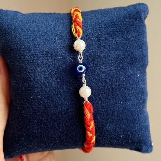 Pearl Evil Eye Rakhi close-up — evil eye charm with white pearl beads