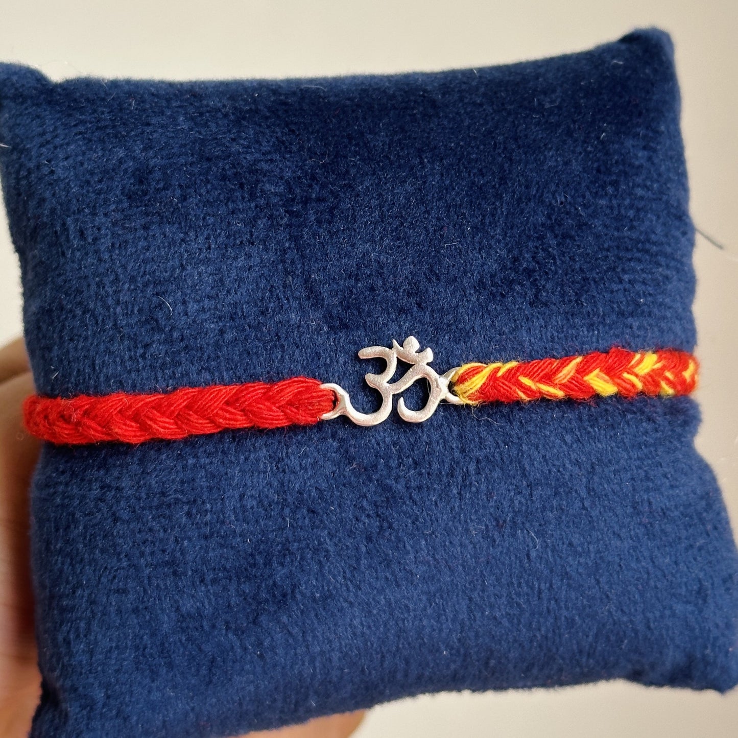 om blessing rakhi close-up — silver om charm detail