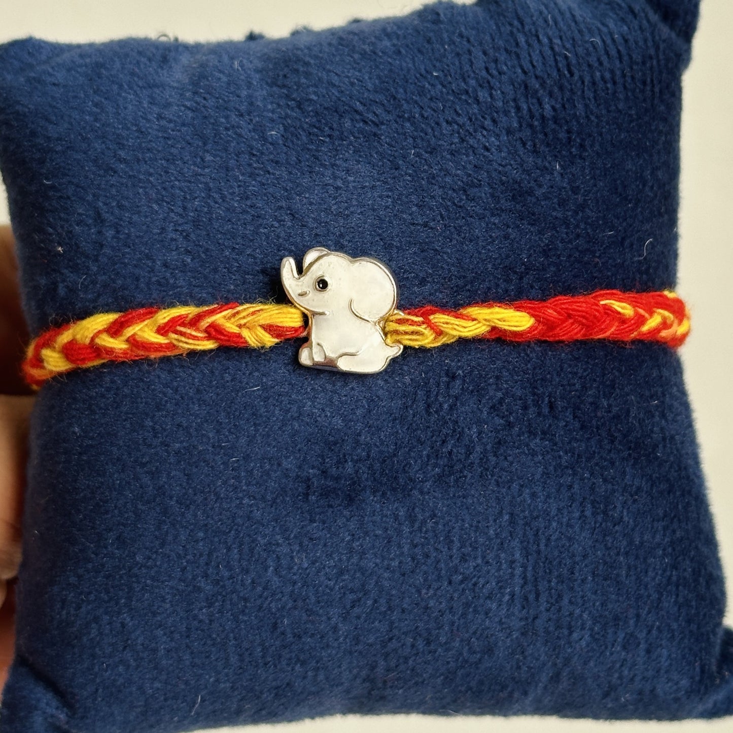 baby elephant rakhi close-up — enamel baby elephant motif detail