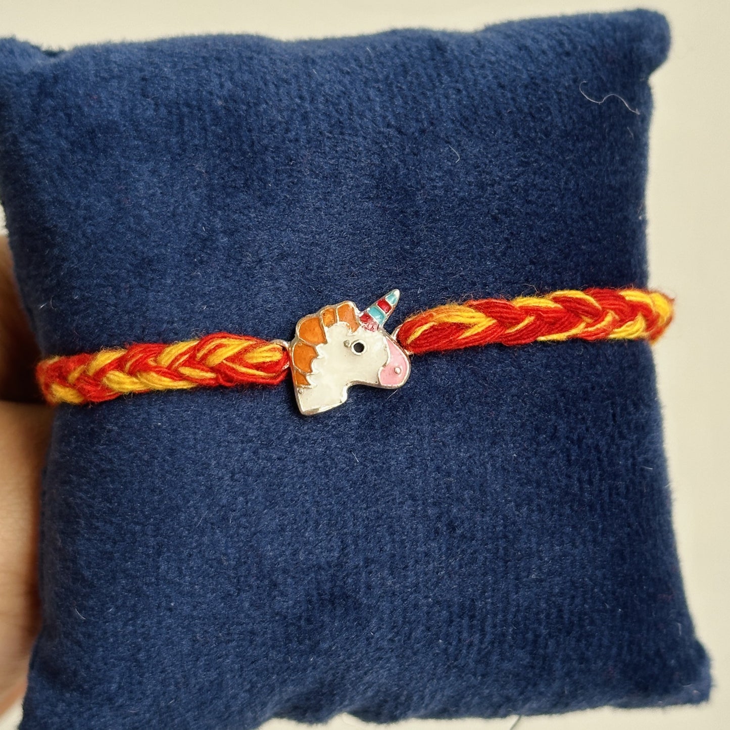 unicorn magic rakhi close-up — enamel unicorn motif detail