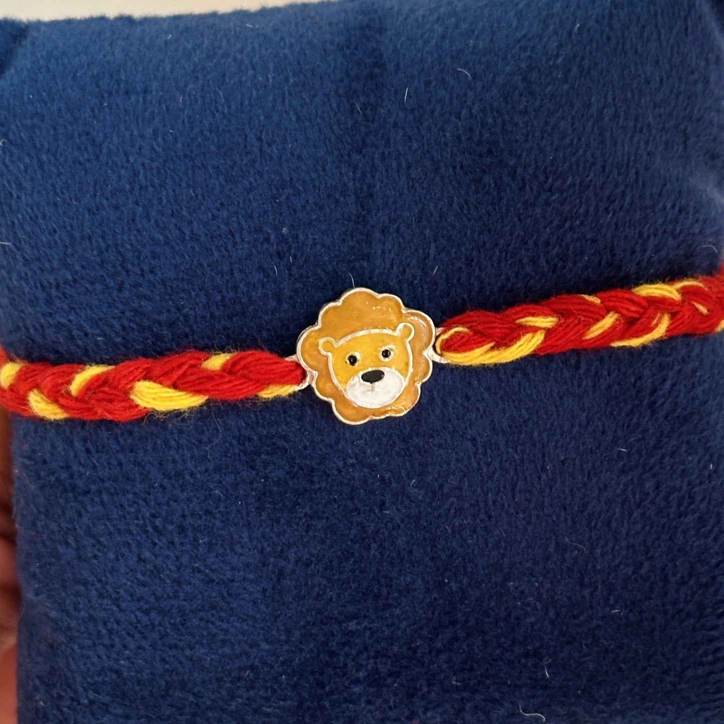 little lion rakhi close-up — enamel lion motif detail