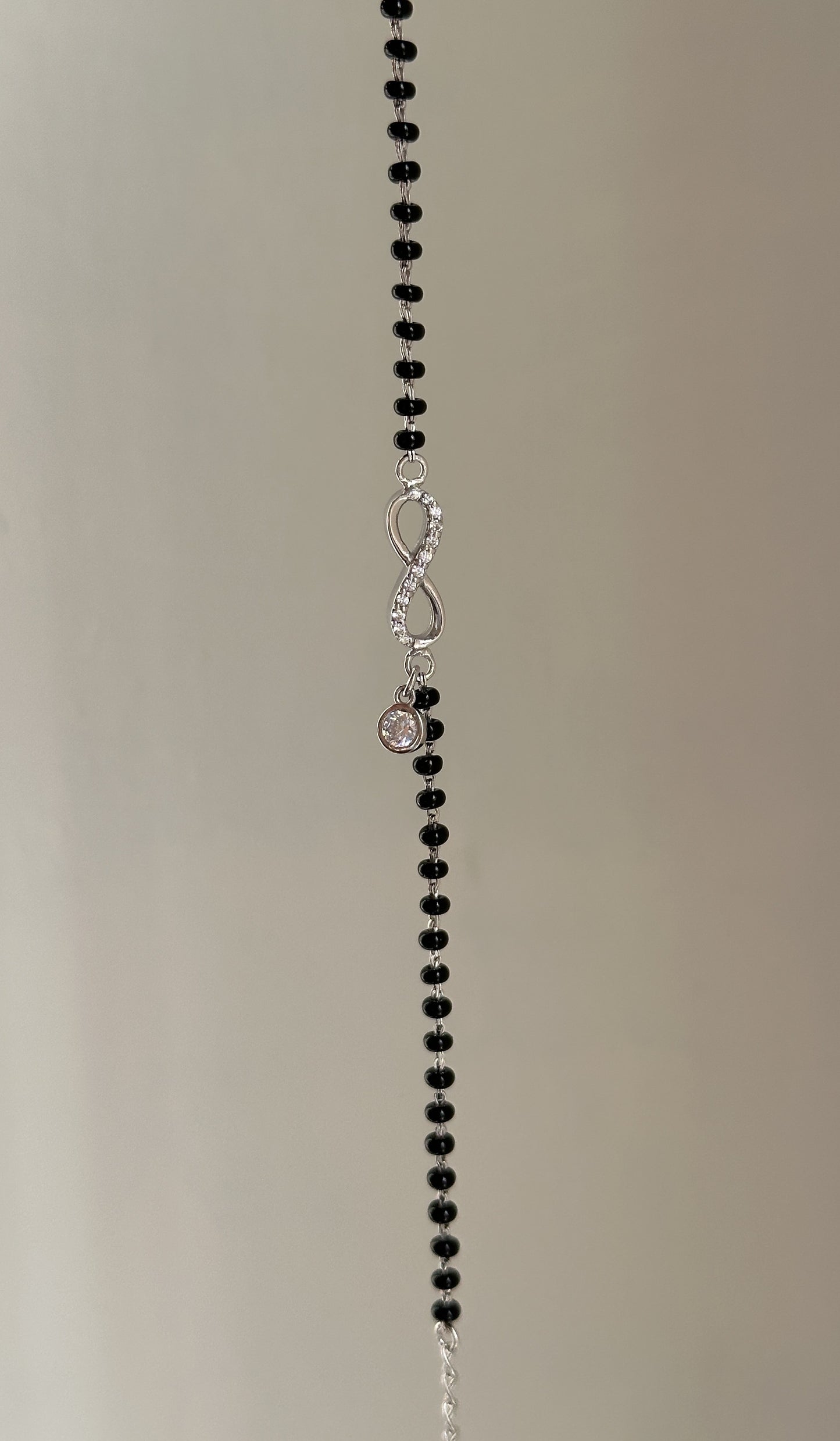 infinity drop hand mangalsutra close-up — hanging zircon charm detail