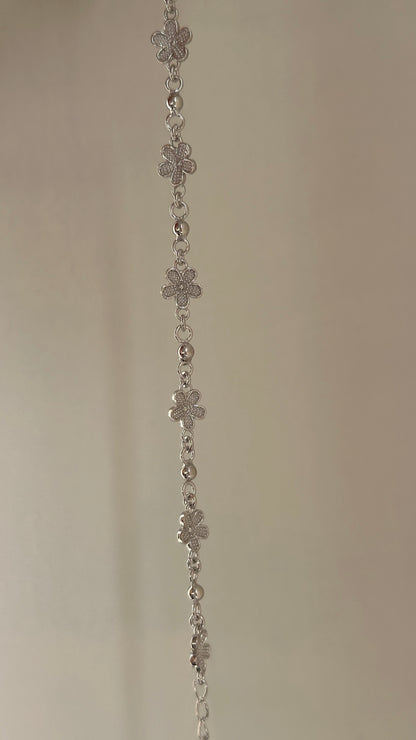 Mini Bloom Bracelet close-up — delicate silver flower detail on fine chain