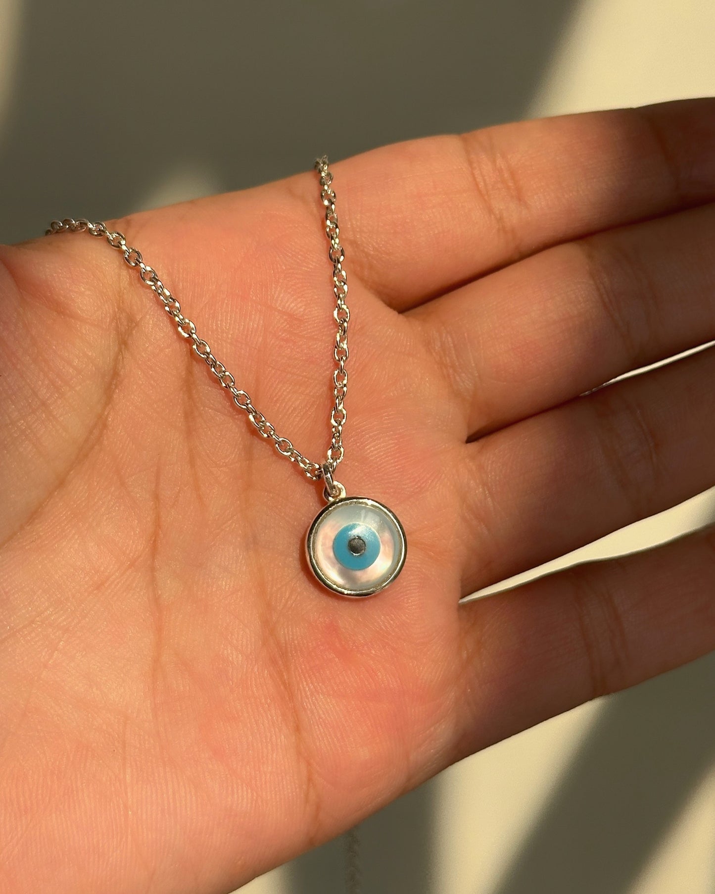statement evil eye neckpiece close-up — large blue evil eye pendant