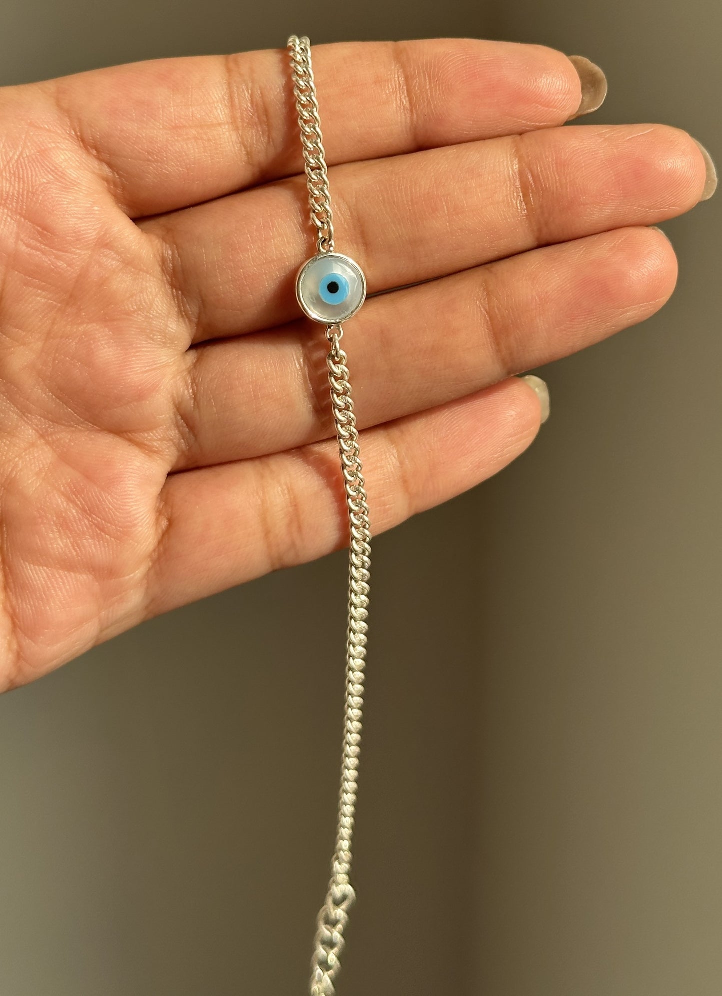 good vibes bracelet close-up — evil eye stone in silver collet setting